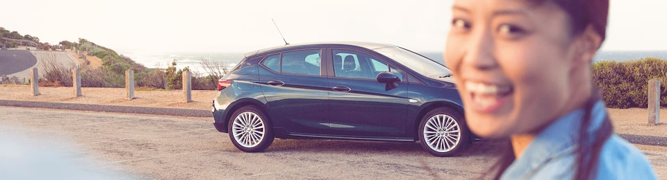 A Woman Smiling in Front of a Holden Astra Hatch